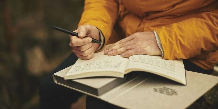 man writing in journal
