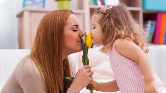 mom and daughter smelling tulip flower